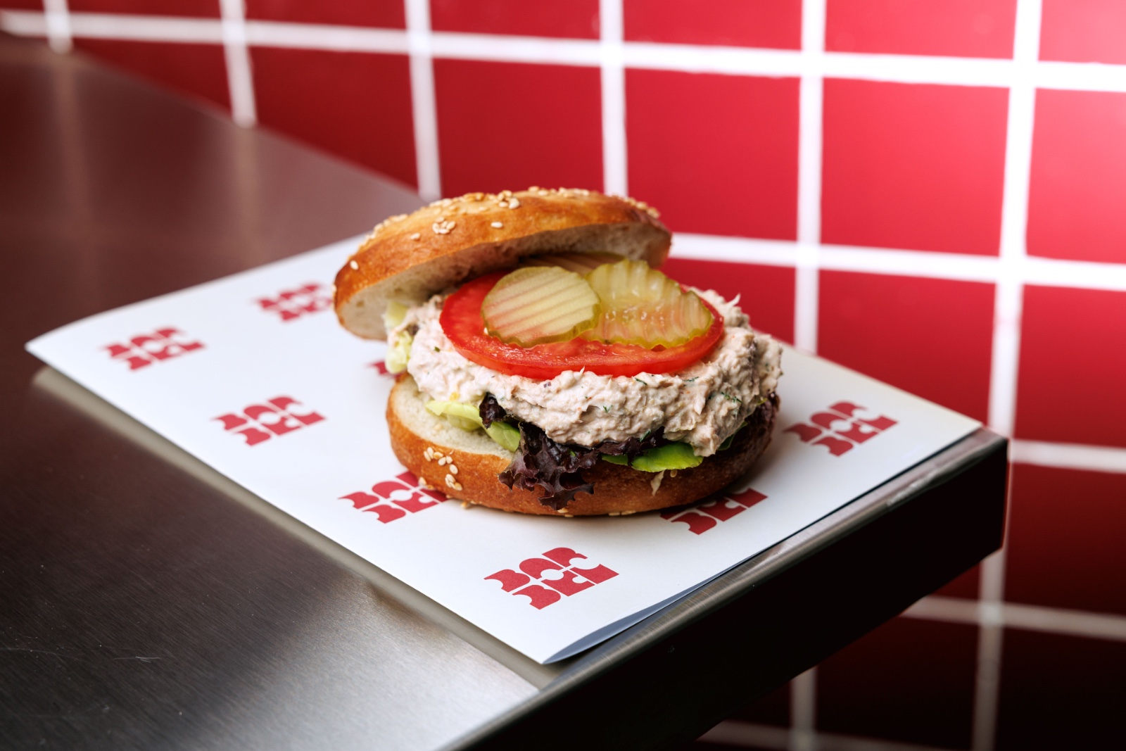 Tuna Togarashi Bagel — tuna, capers, dill, light togarashi mayo, gherkins, tomato, mesclun leaves