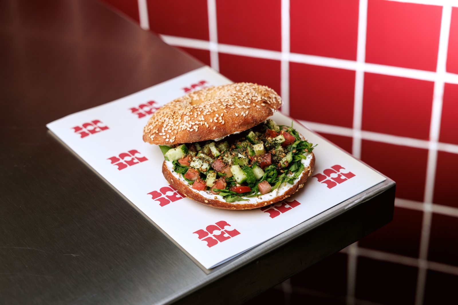 The Goat Bagel — arugule, goat labneh, zaatar, diced tomatos, mint, cucumber ,sour sesame bagel